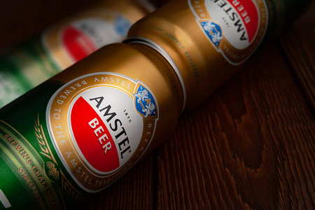 Beer cans. AMSTEL beer in cans on dark brown background with copy space. An internationally renowned brand from the Netherlands. Selective soft focus. Kiev. Ukraine. June-26.2021.のeditorial素材