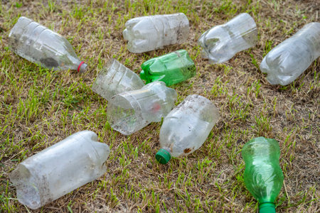 Plastic bottles. A pile of used cut dirty plastic bottles lie on the grass. Environmental pollution...