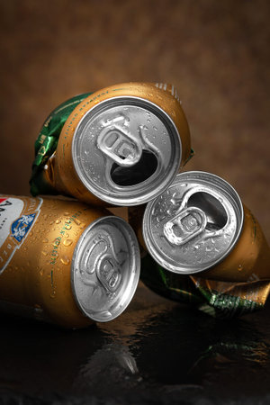 Beer cans. Wet crumpled and full beer cans with drops on a dark background, close-up. AMSTEL is a...