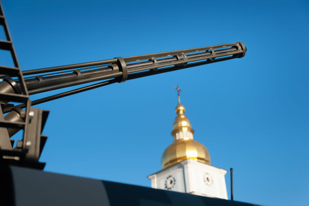 The muzzle of a cannon in the background of the church. Exhibition of military equipment in Kiev....