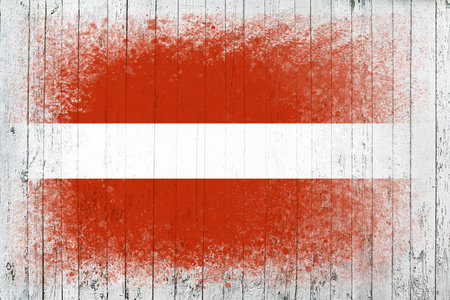 Flag of Latvia. Flag is painted on a white wooden surface. wooden background. Plywood surface. copyspace. textured creative backgroundの写真素材