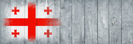 Flag of Georgia. Flag is painted on a gray wooden plank surface. wooden background. Plywood surface. copyspace. textured creative backgroundの写真素材