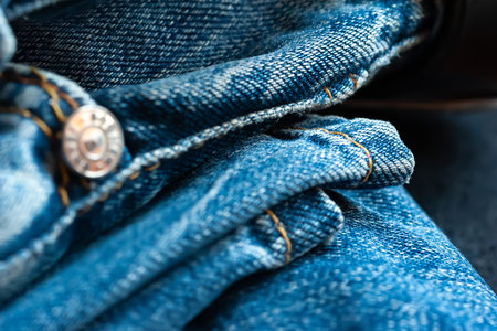 Denim background. Jeans with yellow stitching and rivet. macro image. selective soft focusの写真素材