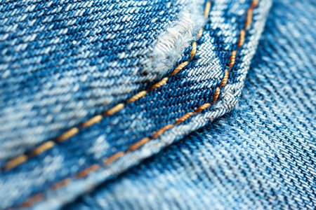 Jeans background. Close-up of denim fabric with yellow pocket seam. macro image. selective soft...