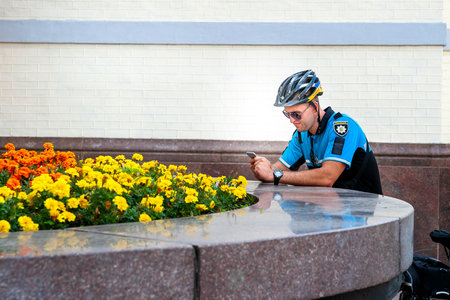 Kyiv, Ukraine - June 27, 2019: Girls' Bike Show-KYIV CYCLE CHIC. The cop uses a smartphone on a bike parade. holiday event.のeditorial素材