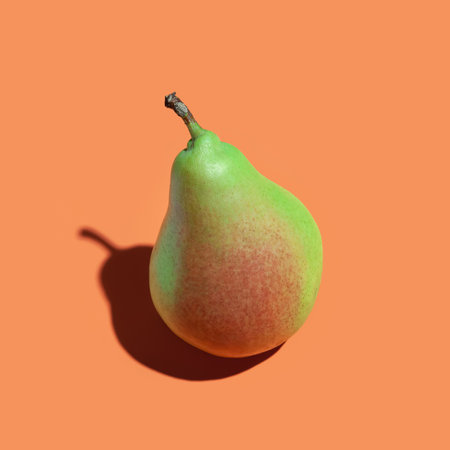 Ripe pearl. Ripe juicy pear on orange background. Ripe fruit. sharp shadowの写真素材