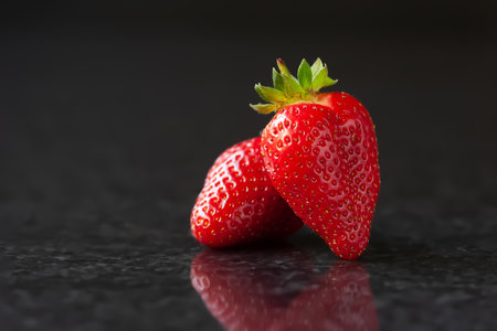 Strawberry. Red ripe strawberries on a black marble background with reflection. selective soft focusの写真素材