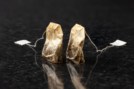 Tea bag. Two used wet tea bags with an empty label on a dark textured background. selective soft...