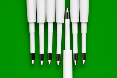 Ballpoint pen refills. Plastic rods for a ballpoint pen. Row of white ink refills on a green backgroundの写真素材