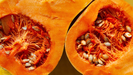Cut pumpkin. Pumpkin texture. Pumpkin seeds close up. Orange vegetable. Diet food concept....
