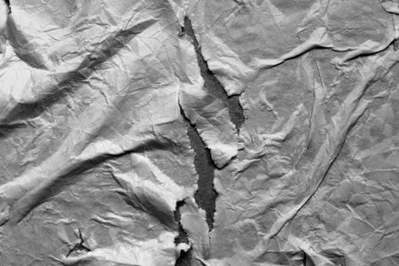 Wet ripped dark paper texture. Empty torn wet paper sheet with surface texture. Paper background. Full frameの写真素材