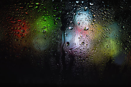 Drops of rain on the window. Water drops on glass. Abstract background. Storefront lights. Texture...