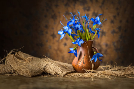 Blue wildflowers. Flowers in a vase on straw. Still life with flowers on an abstract background. Selective focus. AI generatedの素材