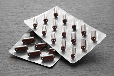 Pills in a blister. Medicine packaging on a dark background. Medicine in tabletsの写真素材