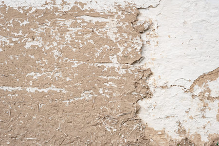Old cracked clay wall. Long cracks of a rural house. Abstract texture
