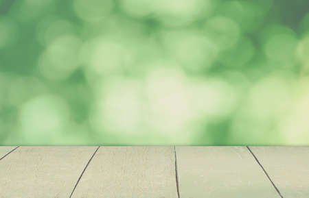 An Empty vintage wooden deck table with natural bokeh background. Product display template.の写真素材