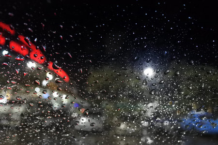 Rain drops on window with street blur lights