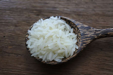 Grain in wooden spoon on wood background.の写真素材
