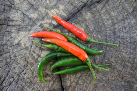 Green pepper and red pepper on wood background.の写真素材