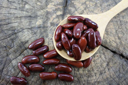 Red beans in a wooden spoon on wood backgroundの写真素材