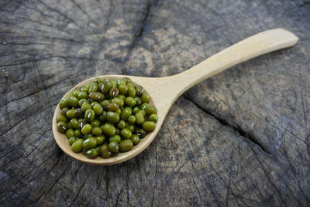 Green beans in a wooden spoon on wood backgroundの写真素材