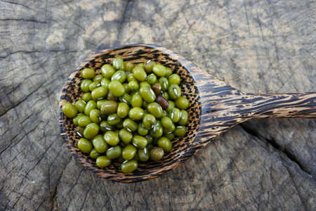 Green beans in a wooden spoon on wood background.の写真素材