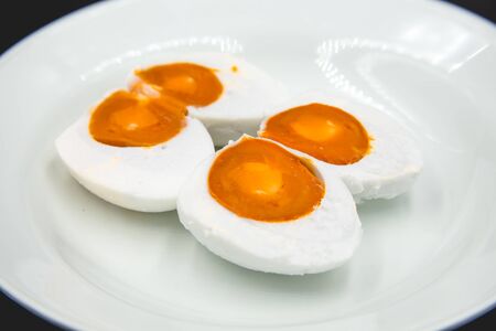 Two salted eggs were sliced on the white plate.の写真素材