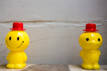 Two yellow plastic dolls have social distance.の写真素材