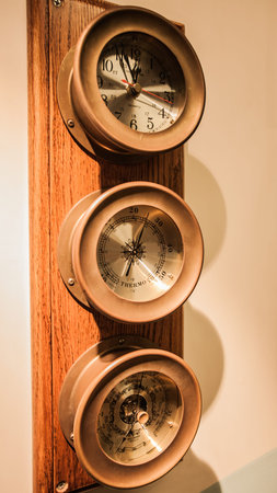 The clock and thermometer are attached to the wall.の写真素材