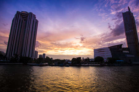 Bangkok, Thailand, August 15 2018.Sunset between the buildings on the Chao Phraya River.のeditorial素材