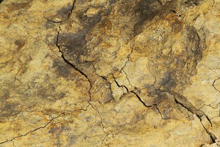 Old brown cracked rock close up photo の写真素材