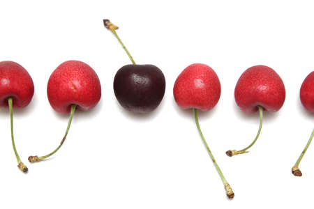 Row of cherries, dark cherry among red onesの写真素材