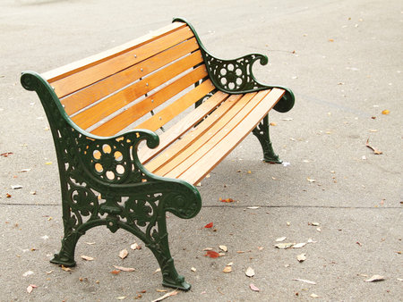 An orange bench in the park on asphalt