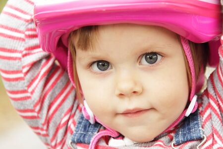 Portrait of little girl with pink bicycle helmetの写真素材