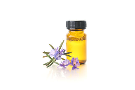 Rosemary essential oil bottle with fresh rosemary flowers isolated on white backgroundの写真素材