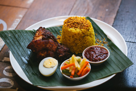 Rice with chicken on a white plate on a wooden table.