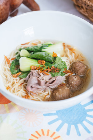 Vietnamese noodle soup with meatballs and vegetables in bowl