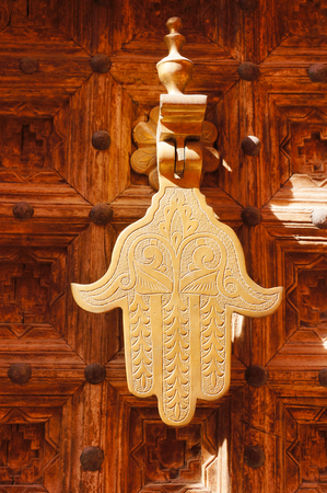 Old knocker in the shape of a hand on a door of a traditional Moroccan house in Marrakech, Morocco の写真素材