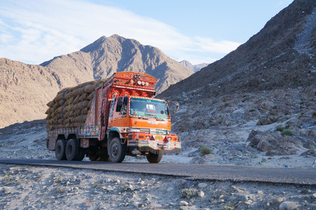 Decorative old orange  truck with Karakoram mountain range in the backgroundのeditorial素材