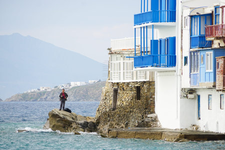 Mykonos,Greece- April 11,2016: Unidentified tourist taking photograph by the sea of Little Venice in Mykonos, Greece.のeditorial素材