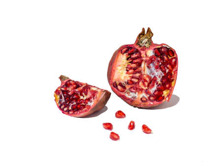 Pomegranate on white background. Fruits. Minimalism. White. Red. Useful product. Ripe. Fruit iridescent in the light.の写真素材