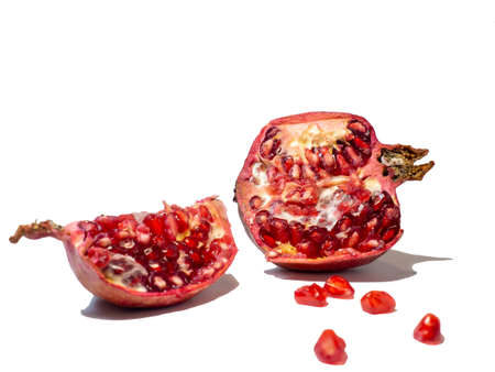 Pomegranate on white background. Fruits. Minimalism. White. Red. Useful product. Ripe. Fruit iridescent in the light.の写真素材