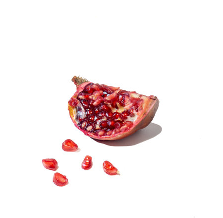 Pomegranate on white background. Fruits. Minimalism. White. Red. Useful product. Ripe. Fruit iridescent in the light.の写真素材