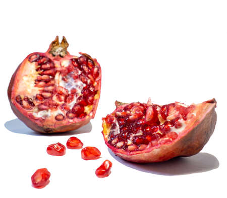 Pomegranate on white background. Fruits. Minimalism. White. Red. Useful product. Ripe. Fruit iridescent in the light.の写真素材