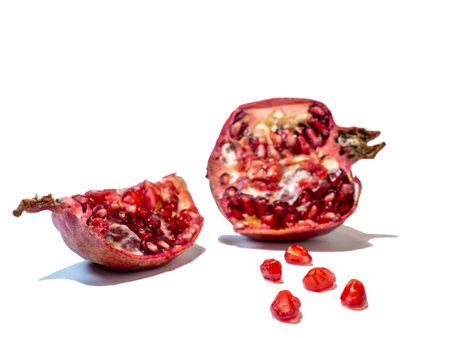 Pomegranate on white background. Fruits. Minimalism. White. Red. Useful product. Ripe. Fruit iridescent in the light.の写真素材