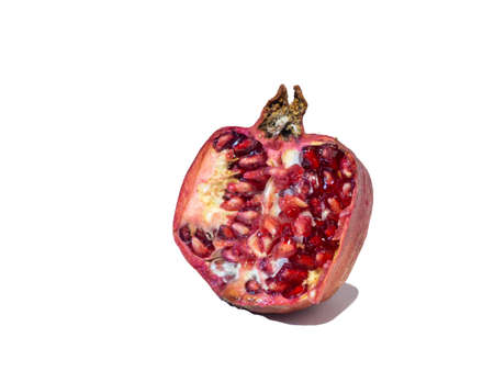 Pomegranate on white background. Fruits. Minimalism. White. Red. Useful product. Ripe. Fruit iridescent in the light.の写真素材