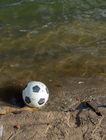 Soccer ball in the water. The ball fell into the riverの写真素材