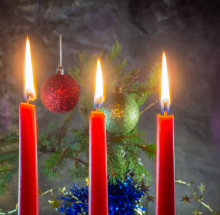 Christmas red candles are burning on the background of fir branches. Christmas decoration. New Year atmosphereの写真素材
