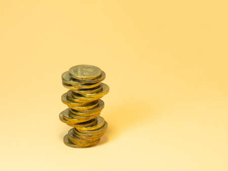 A turret made of coins. Money on yellow backgroundの写真素材