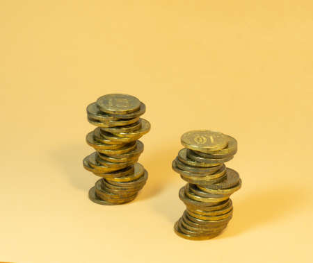 Two turrets made of coins. Money on yellow backgroundの写真素材